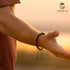UNIQAL Edelsteinarmband in warmem Licht bei Sonnenuntergang – Symbol für Stärke und Erdung